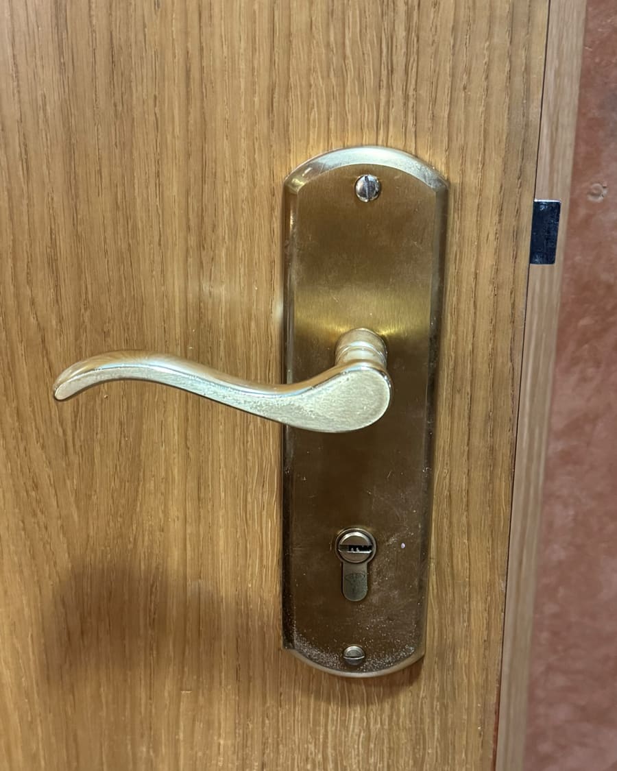 Manilla y bombín montados en una puerta de madera